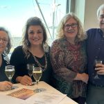 Small groups of people smile on a dinner cruise.