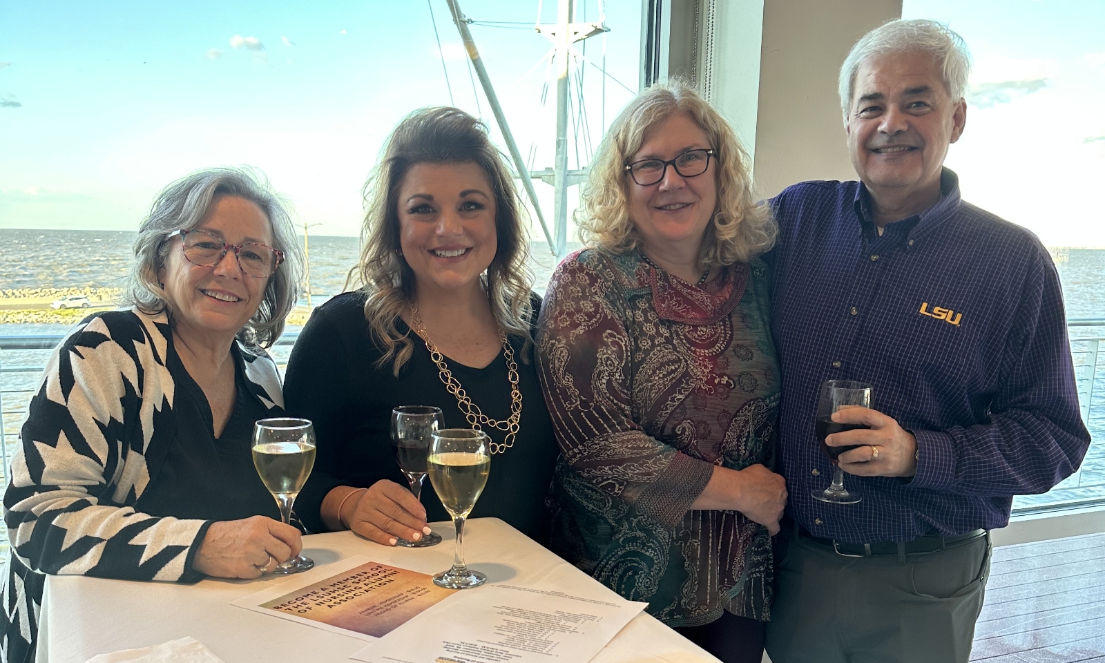 Small groups of people smile on a dinner cruise.