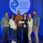 Six LSU Health New Orleans School of Nursing faculty members standing together in front of the American Psychiatric Nurses Association stage backdrop